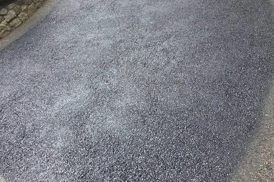 Restored tarmac driveway curving beside a stone wall in County Kilkenny
